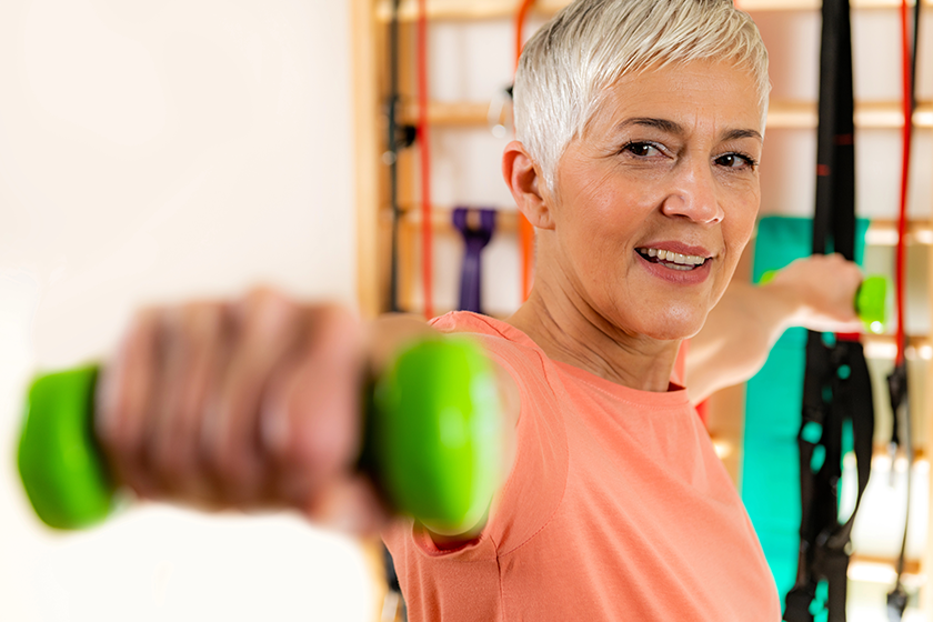 Portrait of senior woman exercising with dumbbells 